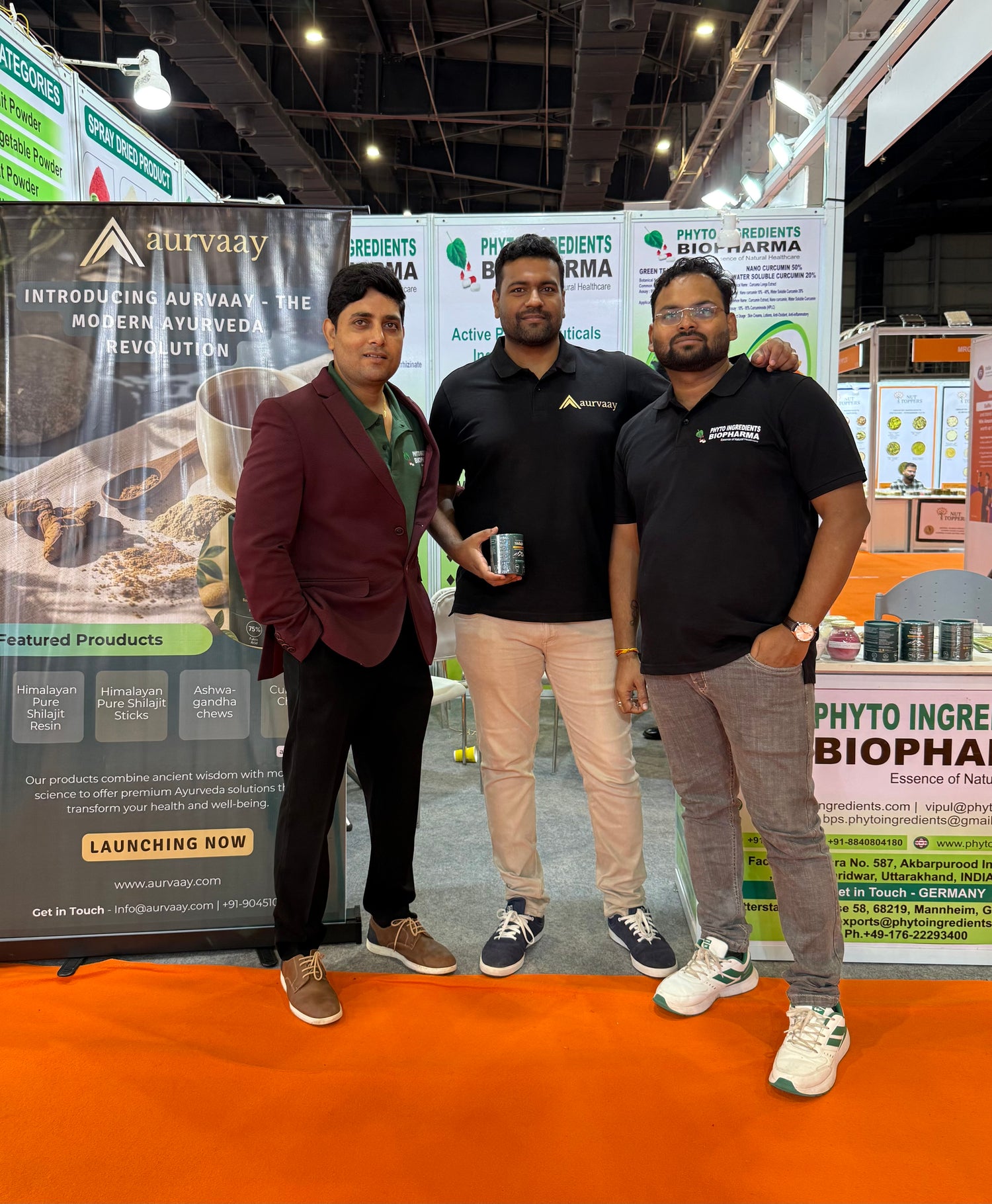 Founders standing together at a trade show with banners in the background